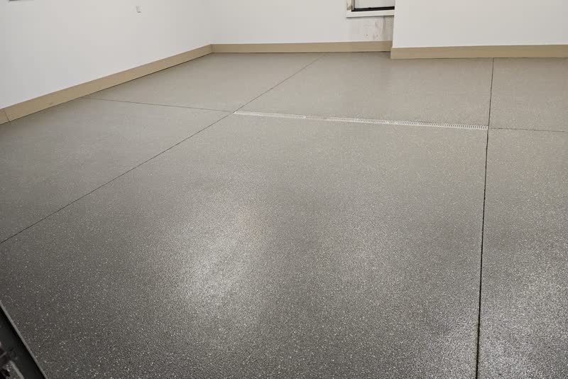 Three-car garage with finished polyurea floor coating in neutral flake palette